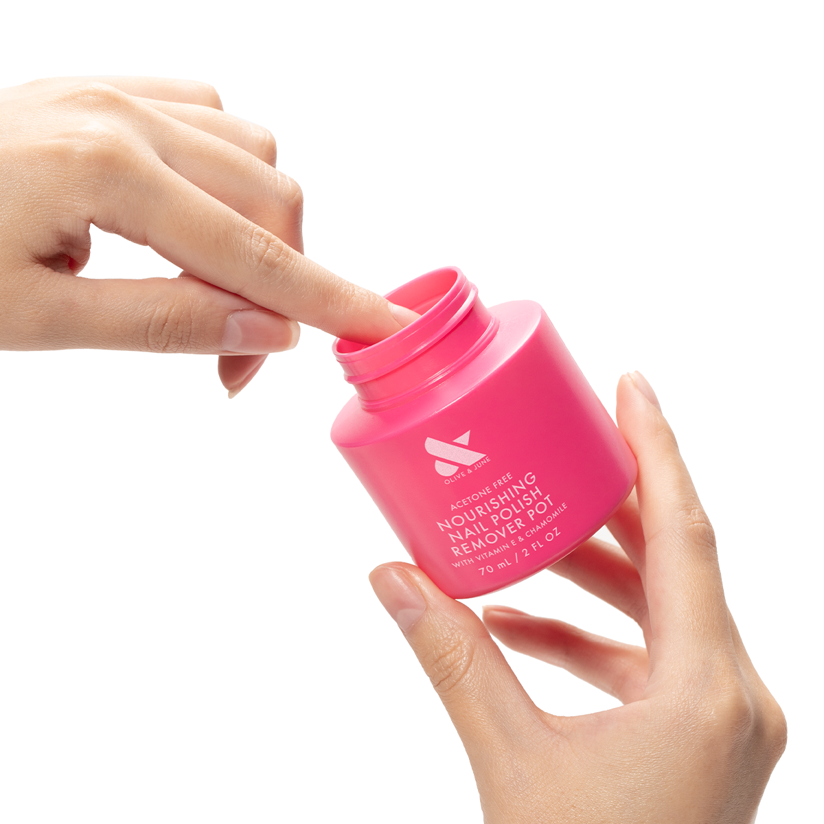 Hands dipping a finger into a bright pink Nourishing Remover Pot for quick, nourishing nail polish removal with care ingredients