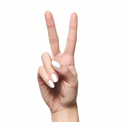 Hand showing peace sign with nails painted in crisp white HD quick dry polish on light background
