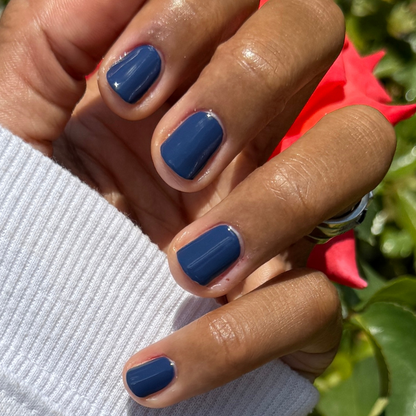 Close-up of smooth gel polish nails painted with Ack, A Shark! in nautical navy blue for a durable mani by Olive and June