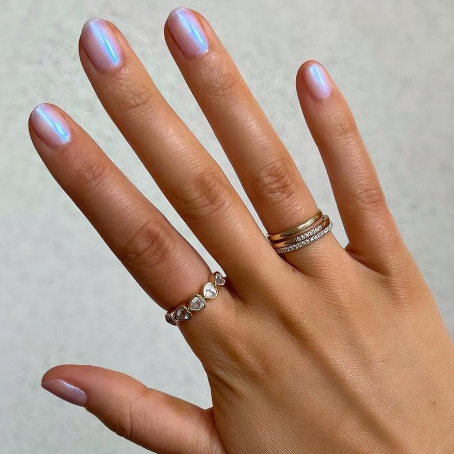 Hand with nails painted Pink Goldfish sheer iridescent polish showing a luminous manicure with delicate shimmer