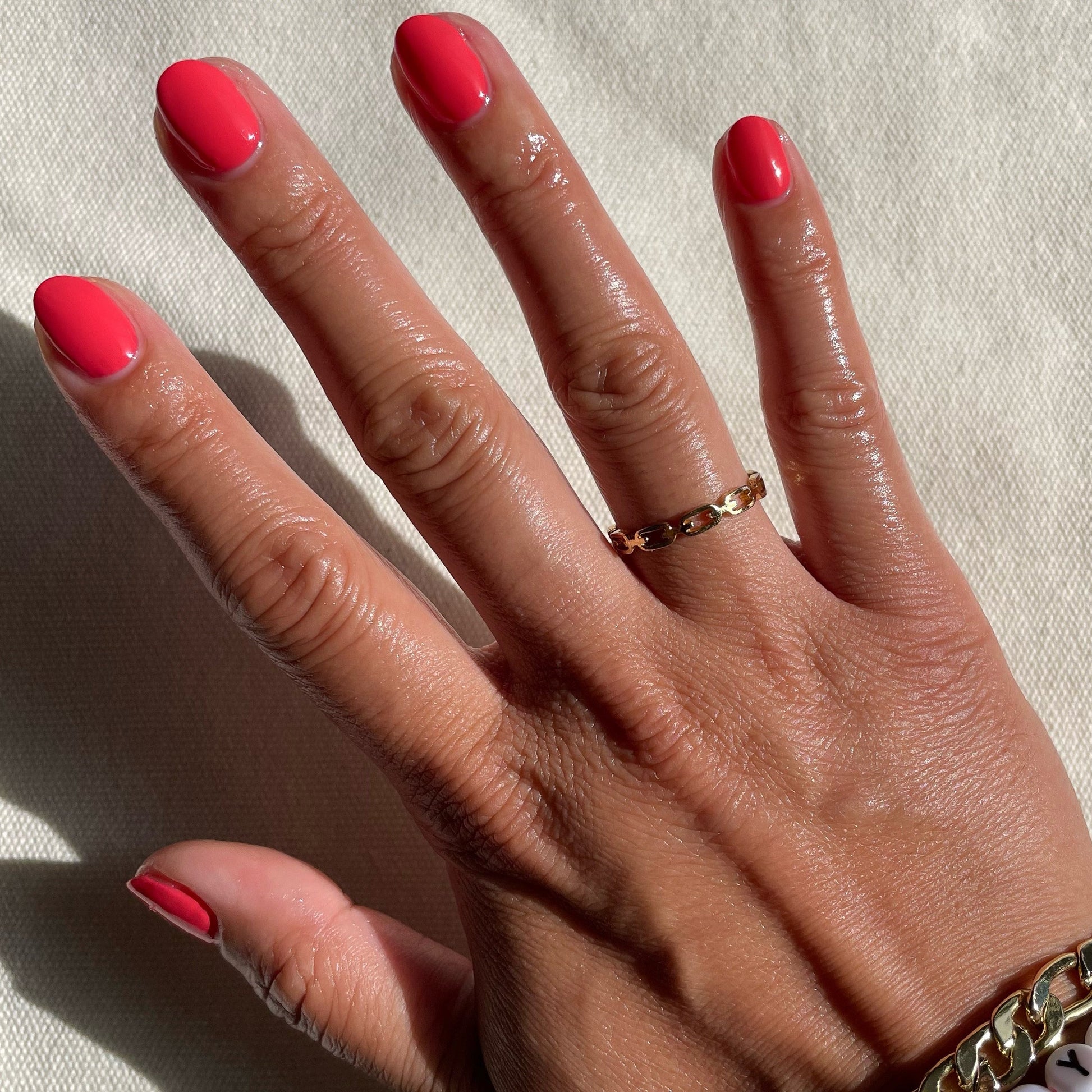 Hand with neatly shaped nails painted in Field Day juicy watermelon red long-lasting polish for a polished mani look