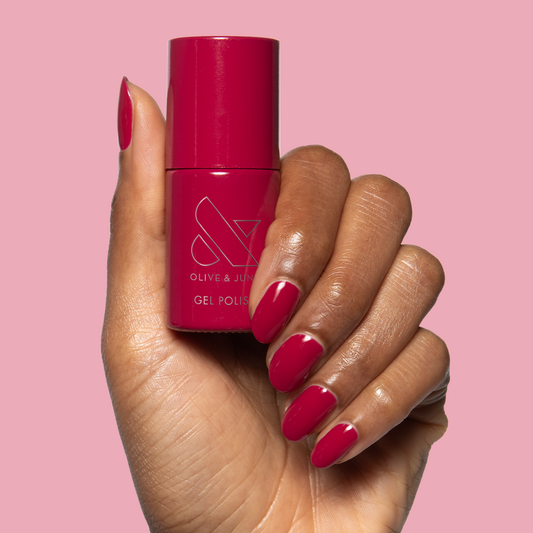 JG - Gel bottle held with matching rich berry gel polish on medium-length nails for a vibrant mani by Olive and June