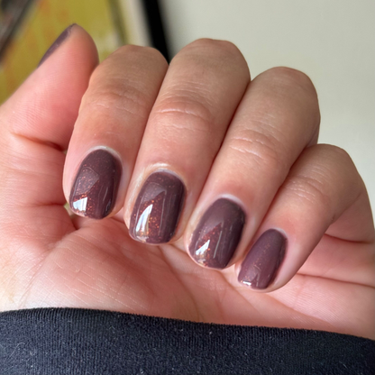 Close-up of hand with short nails painted in Goal Getter - Gel, a chocolatey neutral shade with subtle shimmer manicure