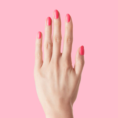 Hand with nails painted in vivid Hot Strawberry gel polish showing bright pink tone against a matching background