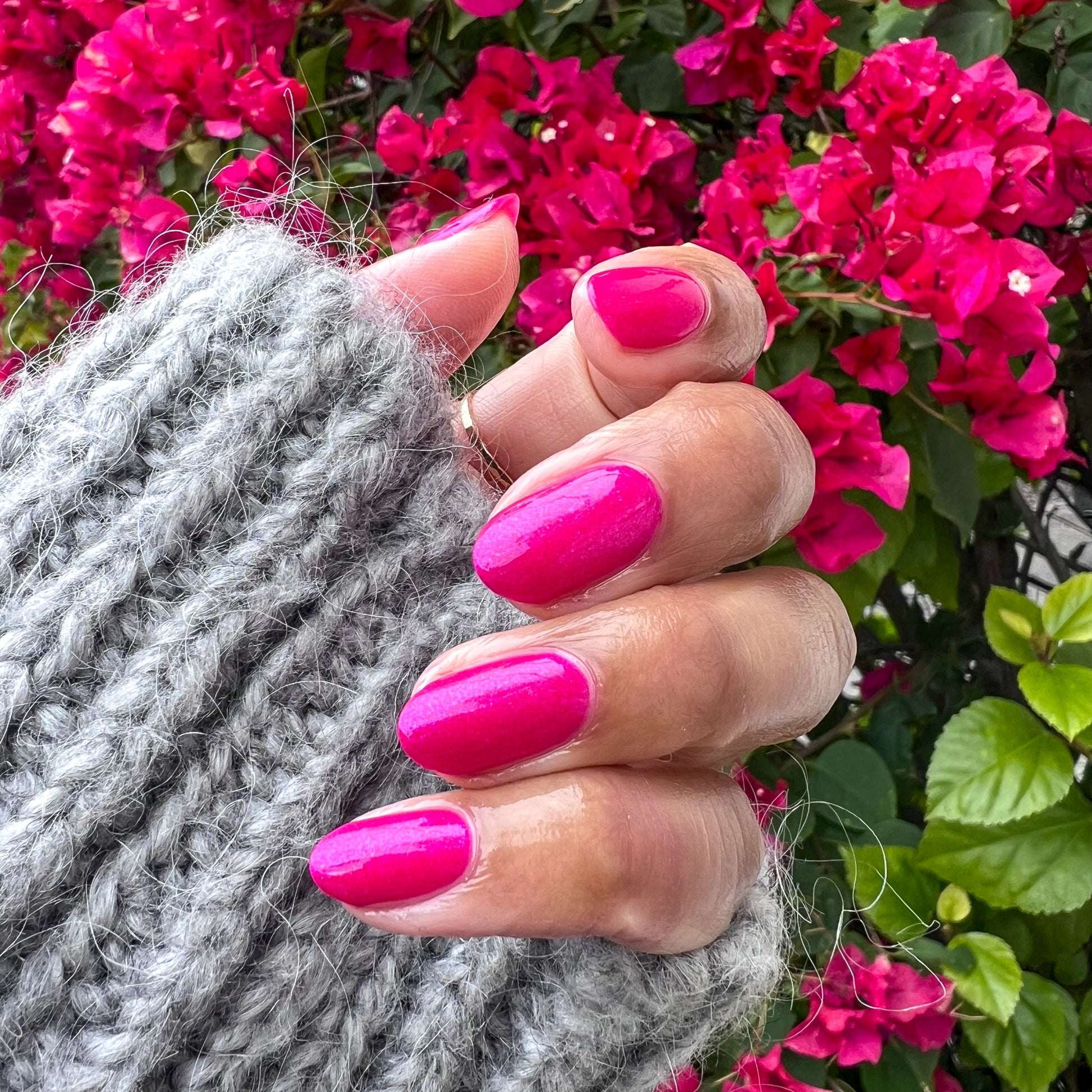 Lily Blooms vibrant magenta gel polish on almond-shaped nails with a glossy, shimmering finish for at-home mani