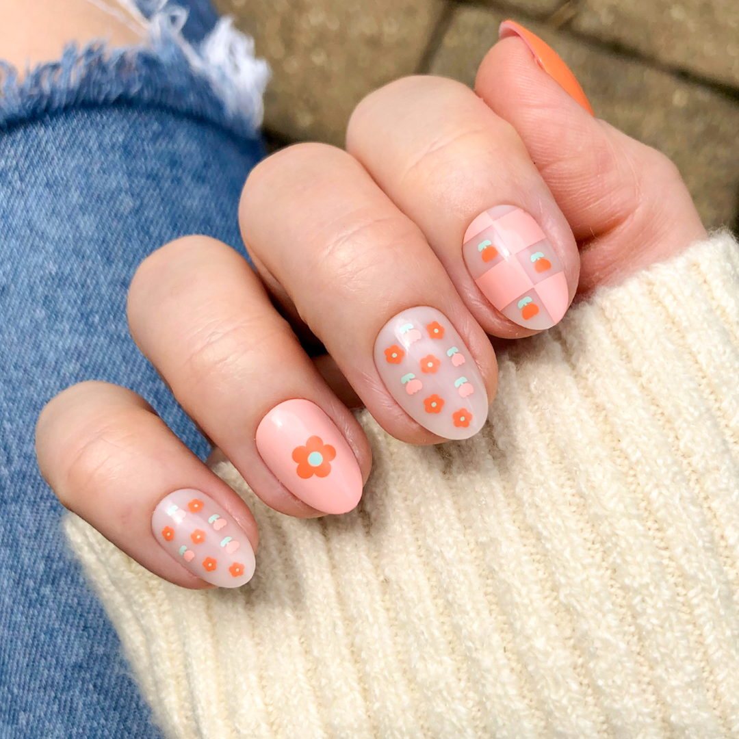 Hand wearing Mixed Quilt Print - Press-On | Short | Almond nails in peach floral and plaid patterns for cozy at home mani