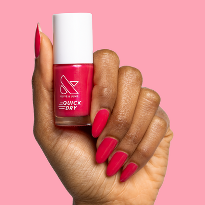 Hand holding Olive and June Berries quick dry polish with matching berry-pink gel mani against soft pink background