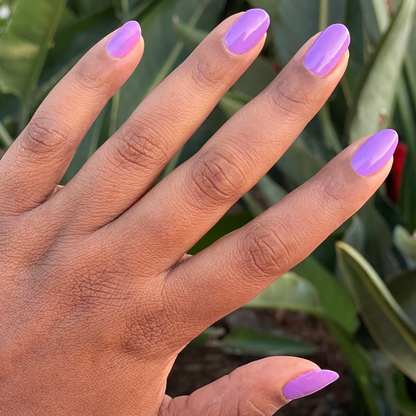 Hand with smooth nails painted bright purple Tennis Skirt polish for a glossy, quick-dry at-home manicure look