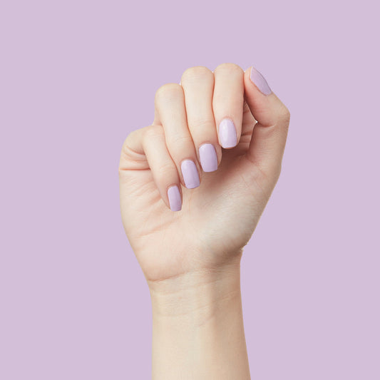 Hand displaying nails painted in soft lilac shade of You're Invited gel polish for a long-lasting manicure by Olive and June