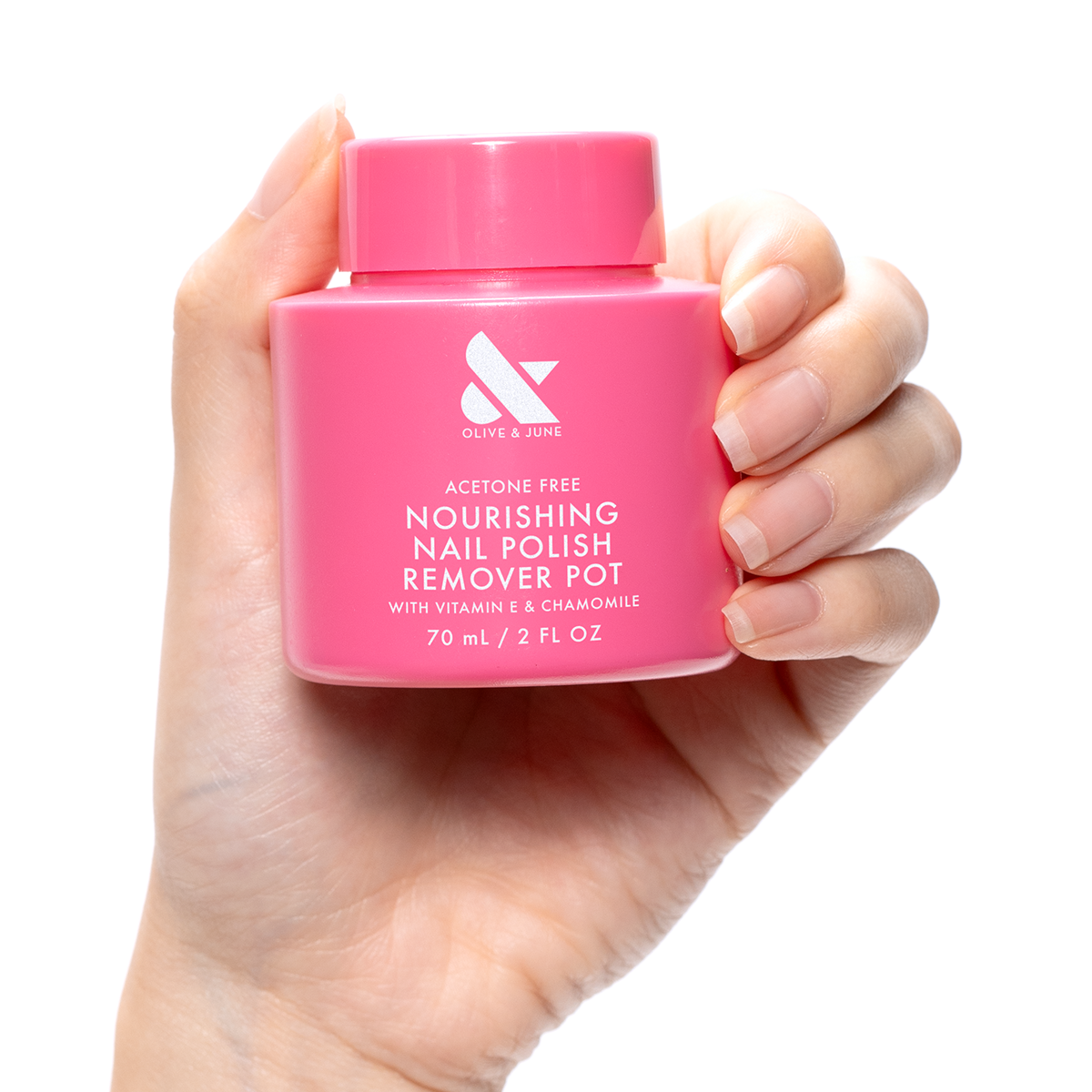 Hand holding a pink Nourishing Remover Pot with vitamin E and chamomile for gentle nail polish removal