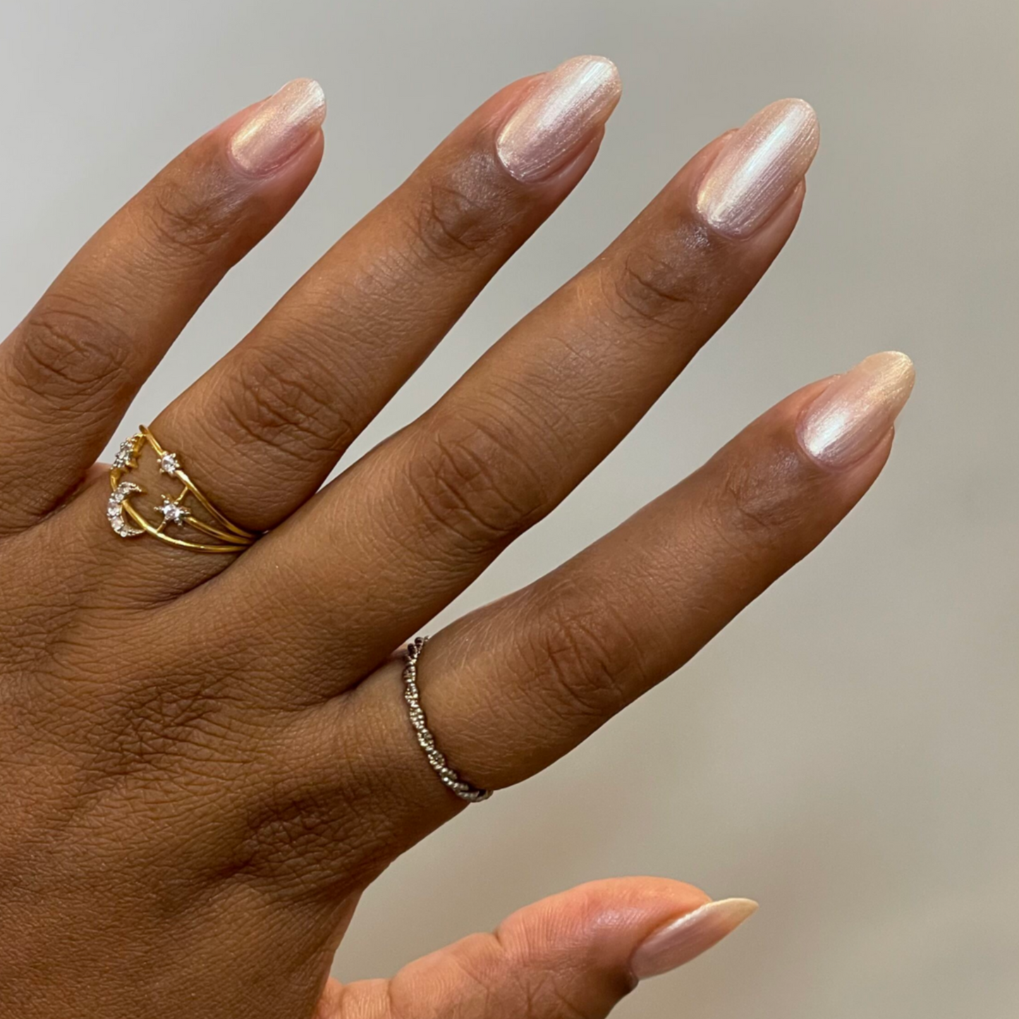 Hand with natural nails polished in sheer, luminous pink using Supernova quick dry gel polish manicure